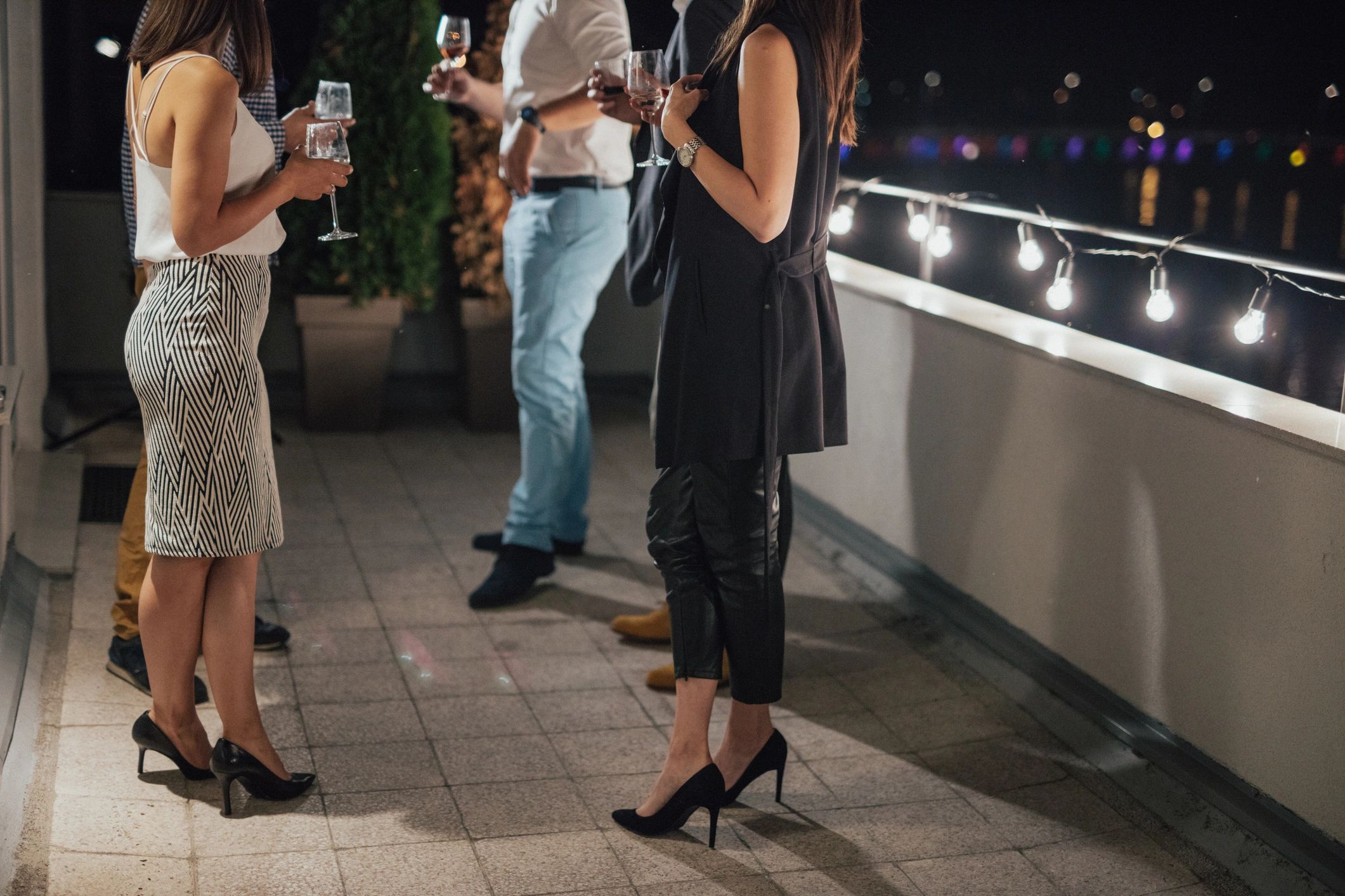 Guests sharing wine and conversation during a rooftop dinner gathering